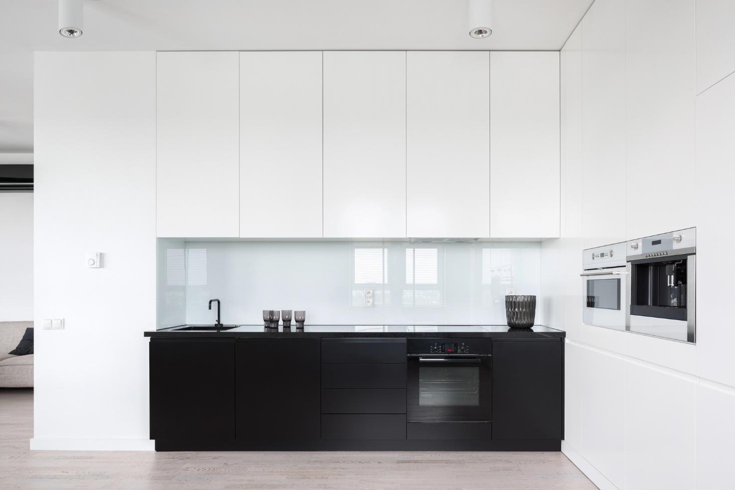 Black and white kitchen with glass backsplash.