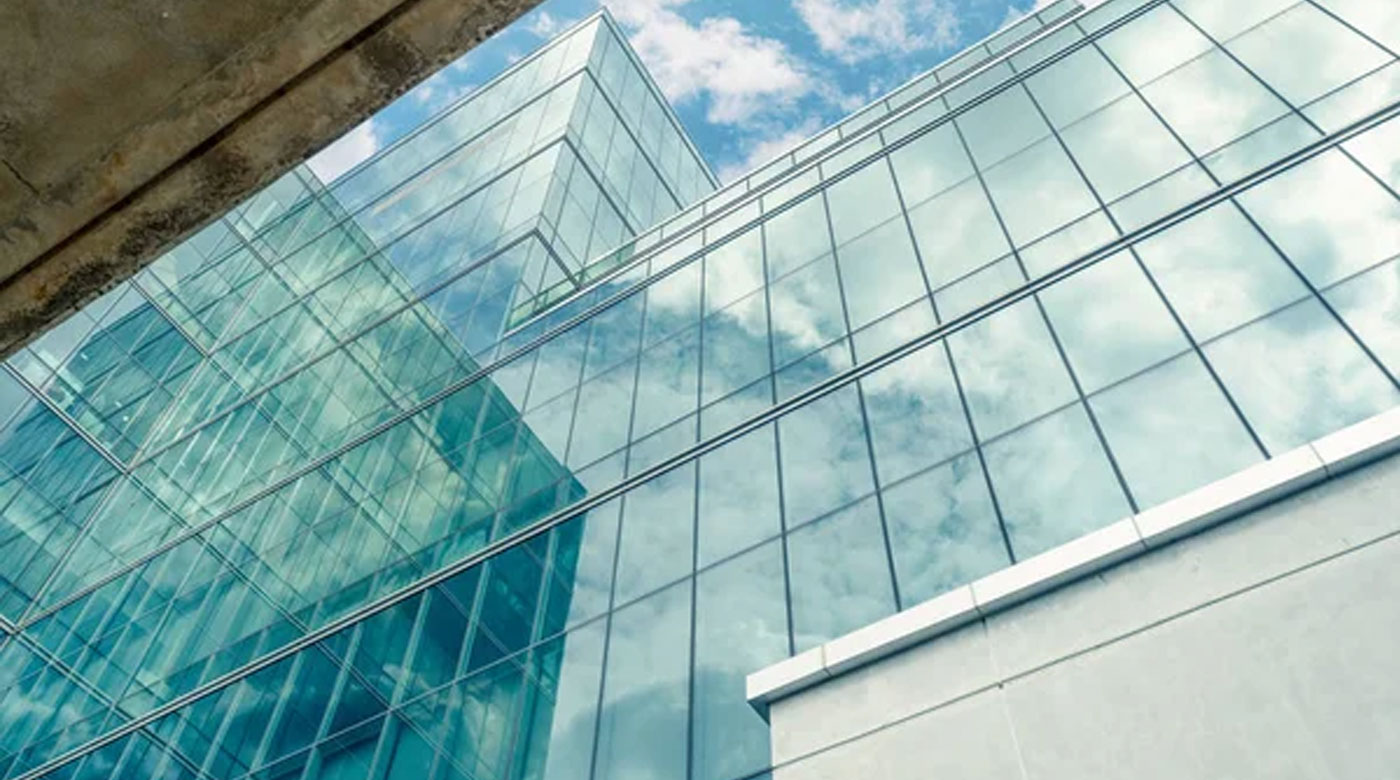 The blue sky overshadows a glass building