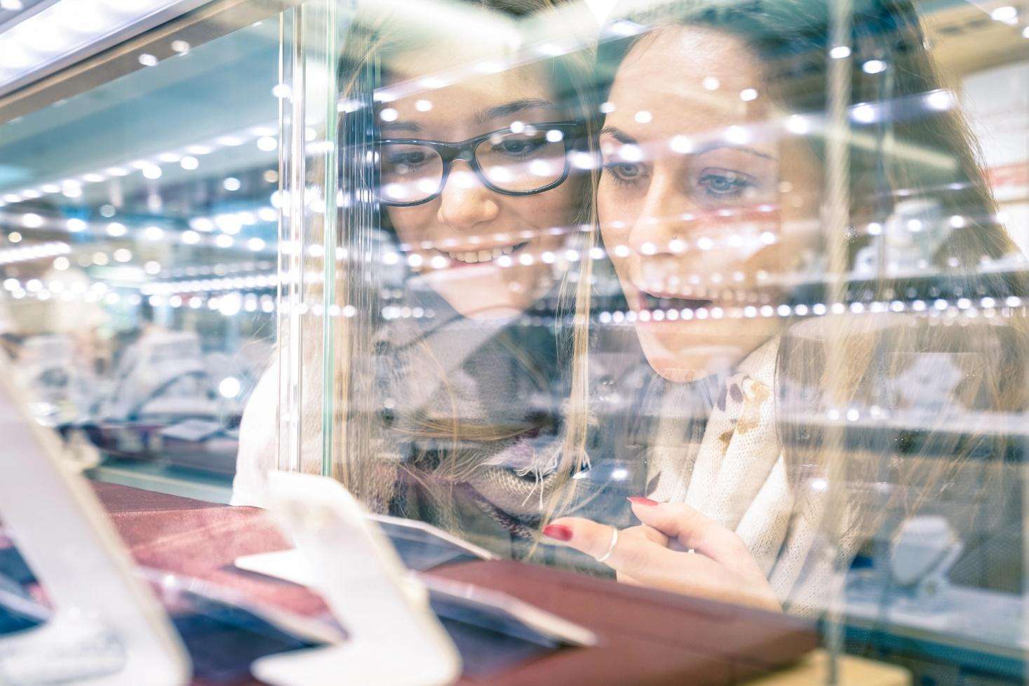 Two people look through a custom glass display case in a jewellery store.