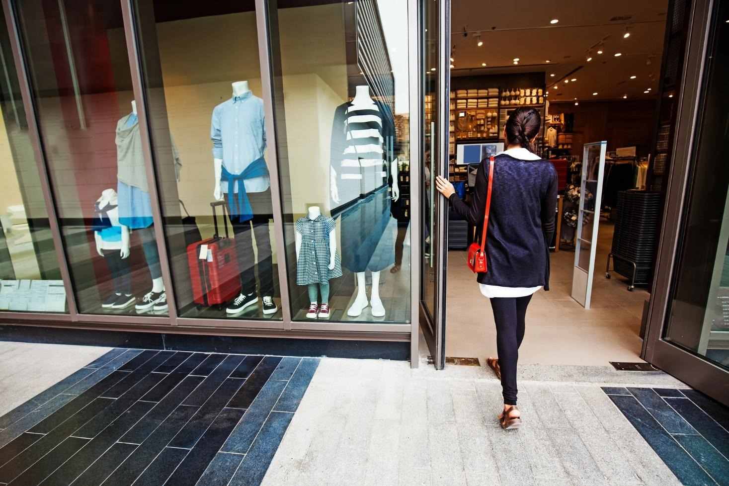 Woman walking into a garment store.